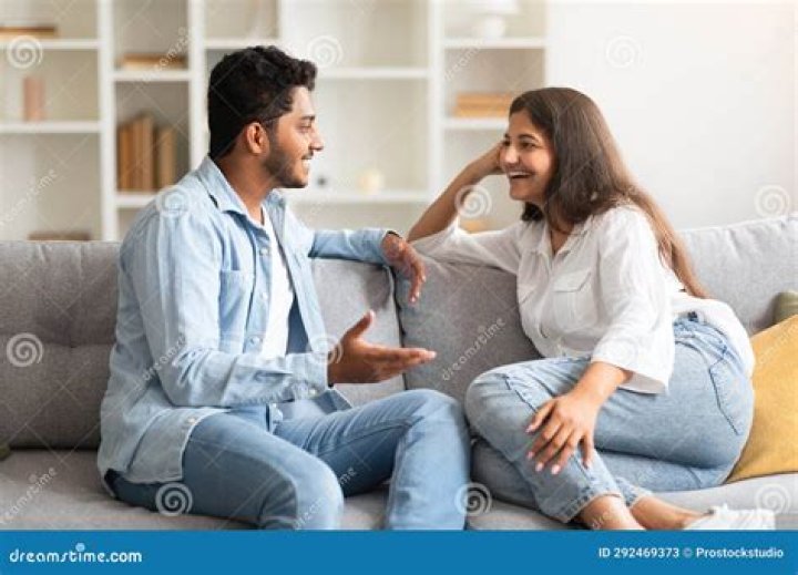 A couple talking on the sofa at home. A young man and woman having a serious discussion on the couch