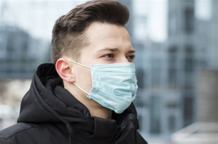 A man wearing a mask while standing in wildfire smoke