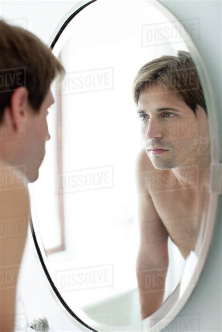 man looking in the mirror for wrinkles
