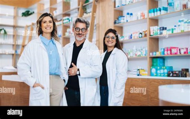 Standing in the store pharmacy, the unrecognizable woman holds over the counter medicine as she tries to make a decision.